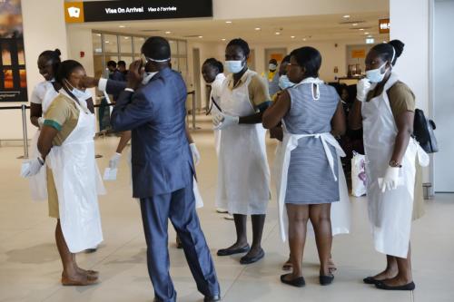 Some health workers with nose marks ready to assist passengers.